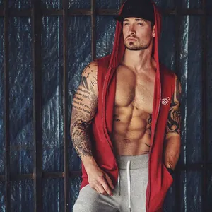 Detail shot of red sleeveless hooded zip-up gym vest on fit male model