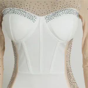 Close-up of elegant slim-fit dress with sparkling rhinestones and sheer mesh sleeves