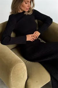 Close-up detail of a black ribbed long-sleeved knit dress with a slim fit design.