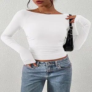 Dettaglio di un crop top bianco a maniche lunghe con scollo a barchetta in maglia a coste