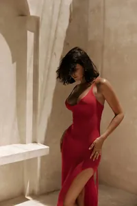 Detail of sexy red knitted beach dress with side slit in a sun-drenched minimalist setting