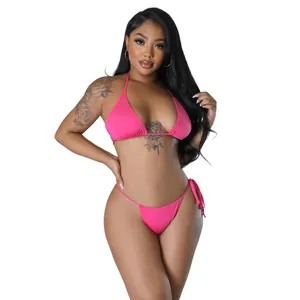 Ganzkörperansicht eines Models in einem leuchtend pinkfarbenen Neckholder-Bikini.