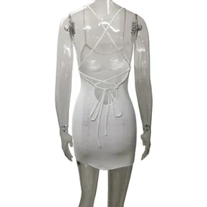 Dettaglio posteriore di un mini abito sexy in maglia bianca senza schienale con lacci