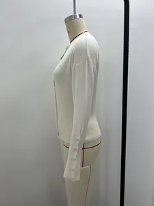 Seitenansicht eines weißen kurzen Strickcardigans mit dekorativen Ärmelknöpfen