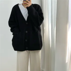 Detailed view of an oversized black V-neck knitted cardigan with large front pockets
