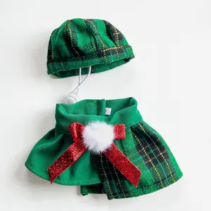Detail of green plaid pet hat and collar set with red bow and white pom-pom.