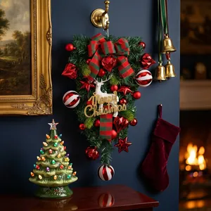 Feestelijke kerst teardrop swag met rode ornamenten en een Merry Christmas bordje.