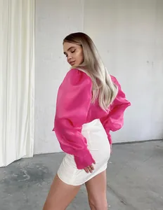 Detalle de una elegante blusa de malla rosa transparente con mangas abullonadas