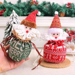 Twee feestelijke gebreide kerstcadeautasjes met trekkoord in de vorm van de Kerstman