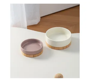 Primo piano di ciotole in ceramica lucida color malva e crema con basi in bambù