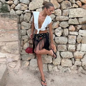 Minifalda étnica de estilo bohemio con bordados florales y flecos largos negros