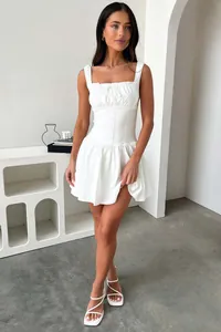 Vue détaillée d'une élégante robe courte blanche sans manches avec taille cintrée