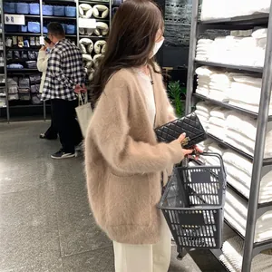Side view of soft beige faux mink fleece cardigan sweater in lifestyle store setting