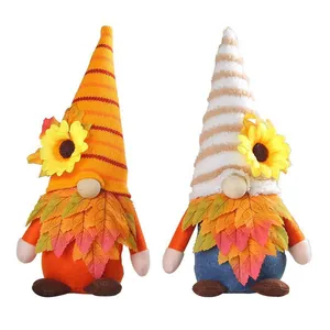 Coppia di gnomi del raccolto autunnale con girasoli luminosi e colletti colorati di foglie d'acero