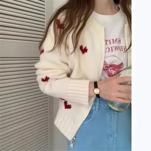 Dettaglio del cardigan in maglia crema da donna con jacquard a cuore rosso e cerniera.