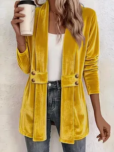 Dettaglio di un cardigan in velluto giallo con bottoni decorativi a doppio petto.