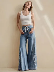 Detail view of Bohemian floral embroidered wide-leg jeans with drawstring waist
