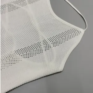 Dettaglio ravvicinato del tessuto in maglia bianca con strisce traforate decorative.
