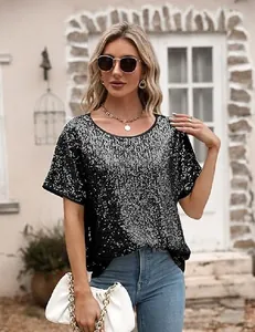 Haut à paillettes noires étincelantes porté par un mannequin dans un cadre extérieur