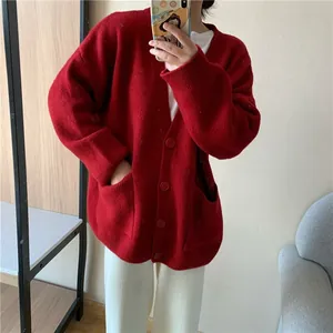 Mirror selfie showing the relaxed fit and knitted texture of a casual red V-neck cardigan.