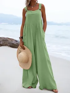 Mono boho verde sin mangas de pierna ancha para mujer lucido en una playa con detalles de botones