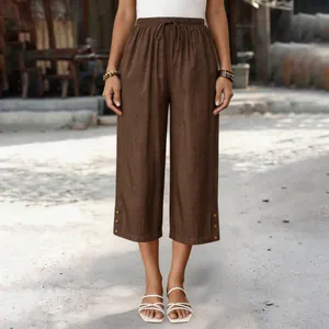 Nahaufnahme einer braunen lockeren Tencel-Denim-Caprihose mit dekorativem Knopfsaum