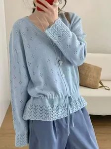 Close-up of light blue hollow-out knitted cardigan with gathered drawstring waist