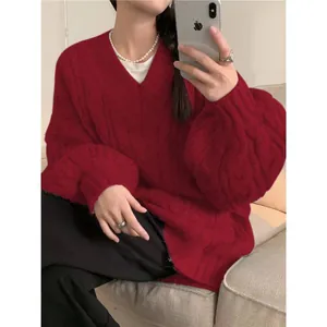 Vista dettagliata di un maglione a trecce rosso scuro con scollo a V e vestibilità comoda.