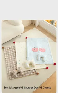 Detail of three cute patterned pet mats with matching U-shaped pillows in cozy home setting