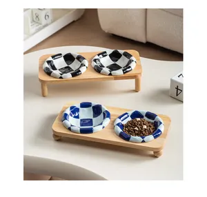Close-up of checkered ceramic pet bowls on a sturdy oak wood stand feeder.