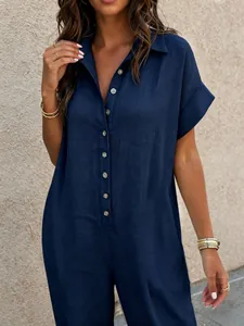 Close-up of a navy blue short-sleeved linen jumpsuit featuring a button-down shirt collar