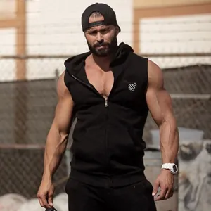 Muscular fitness model wearing a black quick-dry sleeveless hooded vest in outdoor setting.