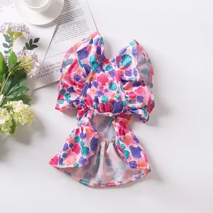 Detailed macro view of a pink pet dress featuring colorful shell and floral prints.