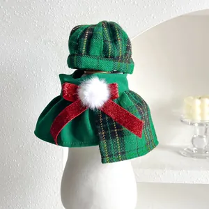 Detail view of the green plaid Christmas pet hat and cape set with a red bow