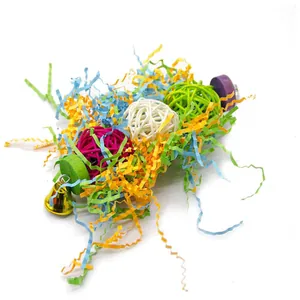 Detail of parrot toy with colorful rattan balls, shredded paper, and a small bell
