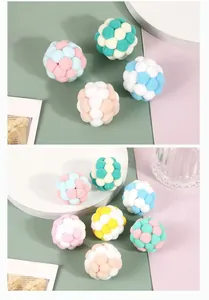 Close-up of colorful plush pom-pom cat toy balls in various color combinations