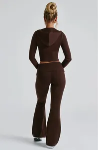 Vista posteriore di una donna che indossa crop top marrone e pantaloni a zampa d'elefante