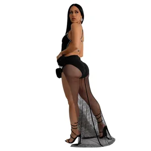 Détail d'un body noir à strass avec robe longue en maille transparente et fente haute