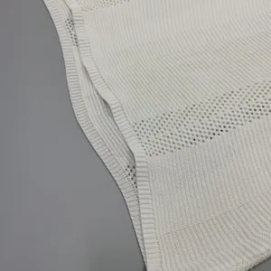 Dettaglio ravvicinato della trama in maglia bianca di un mini abito senza maniche