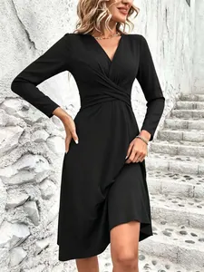 Detail view of the twisted waist and pleated design on a black V-neck long sleeve dress