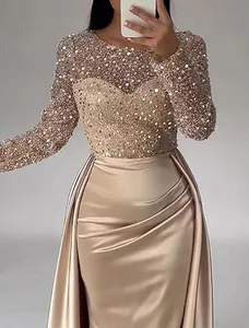 Close-up detail of shimmering sequins and champagne satin fabric on long-sleeved evening gown