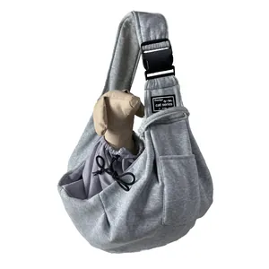 Detailed view of gray fabric pet sling carrier with breathable mesh and side pocket