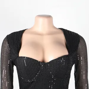 Close-up detail of black sequined dress showing delicate shimmer and low-cut neckline.