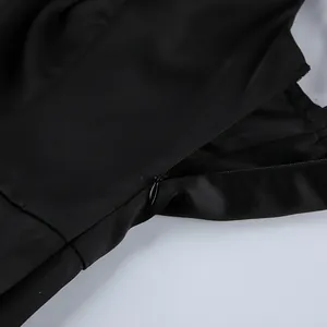 Macro detail of the smooth hidden side zipper on a black satin faux silk camisole