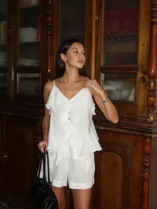 Élégant ensemble en coton blanc avec haut à volants et short porté par un mannequin
