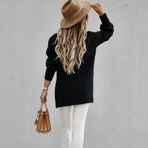 Πίσω όψη γυναίκας που φοράει μαύρο oversized πλεκτό πουλόβερ με άσπρο παντελόνι