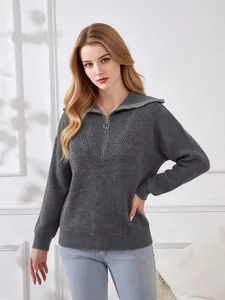 Close-up of a grey oversized V-neck knitted sweater with a half-zip collar design.