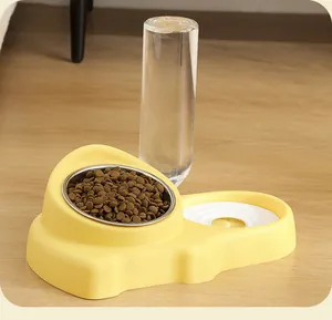 Détail en gros plan de l'ensemble de gamelles automatiques jaunes pour eau et nourriture.