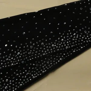 Dettaglio ravvicinato di tessuto nero trasparente con strass brillanti per abiti da sera