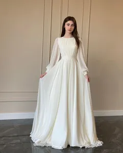 Elegant long sleeve white wedding dress featuring lantern sleeves and pleated bodice detail